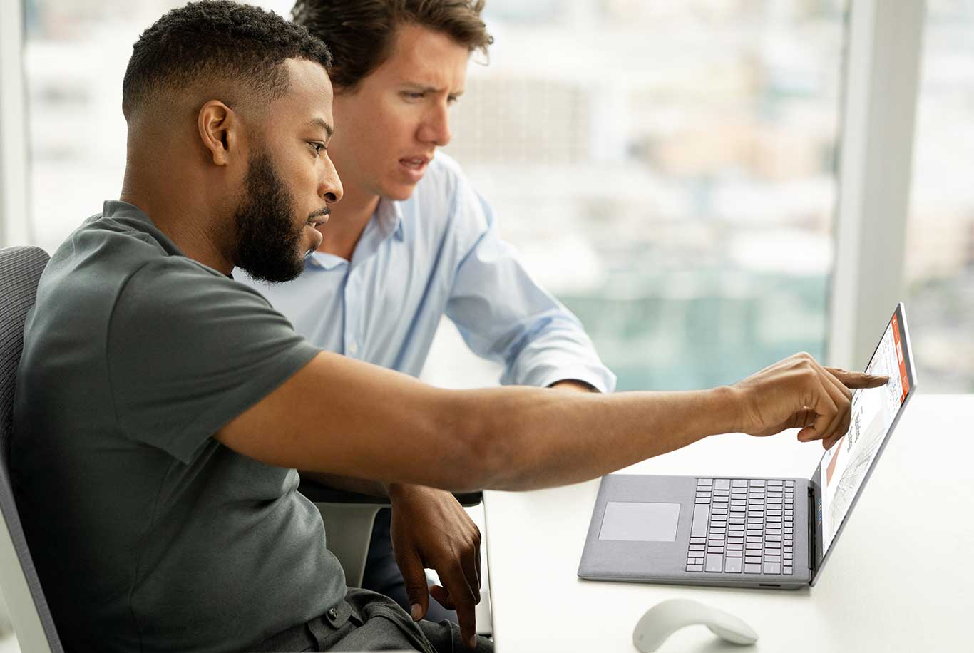 two colleagues in the office using the touchscreen of a Surface Laptop 5